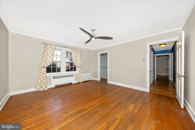 a view of a livingroom with wooden floor and a ceiling fan