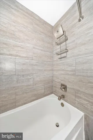a bathroom with a white bath tub and a shower