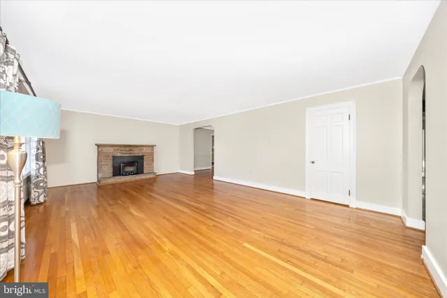 a view of empty room with wooden floor and fireplace