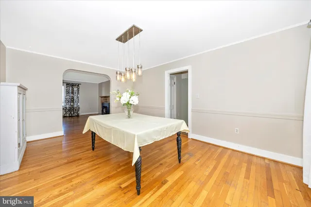 a view of a room with wooden floor table and chairs