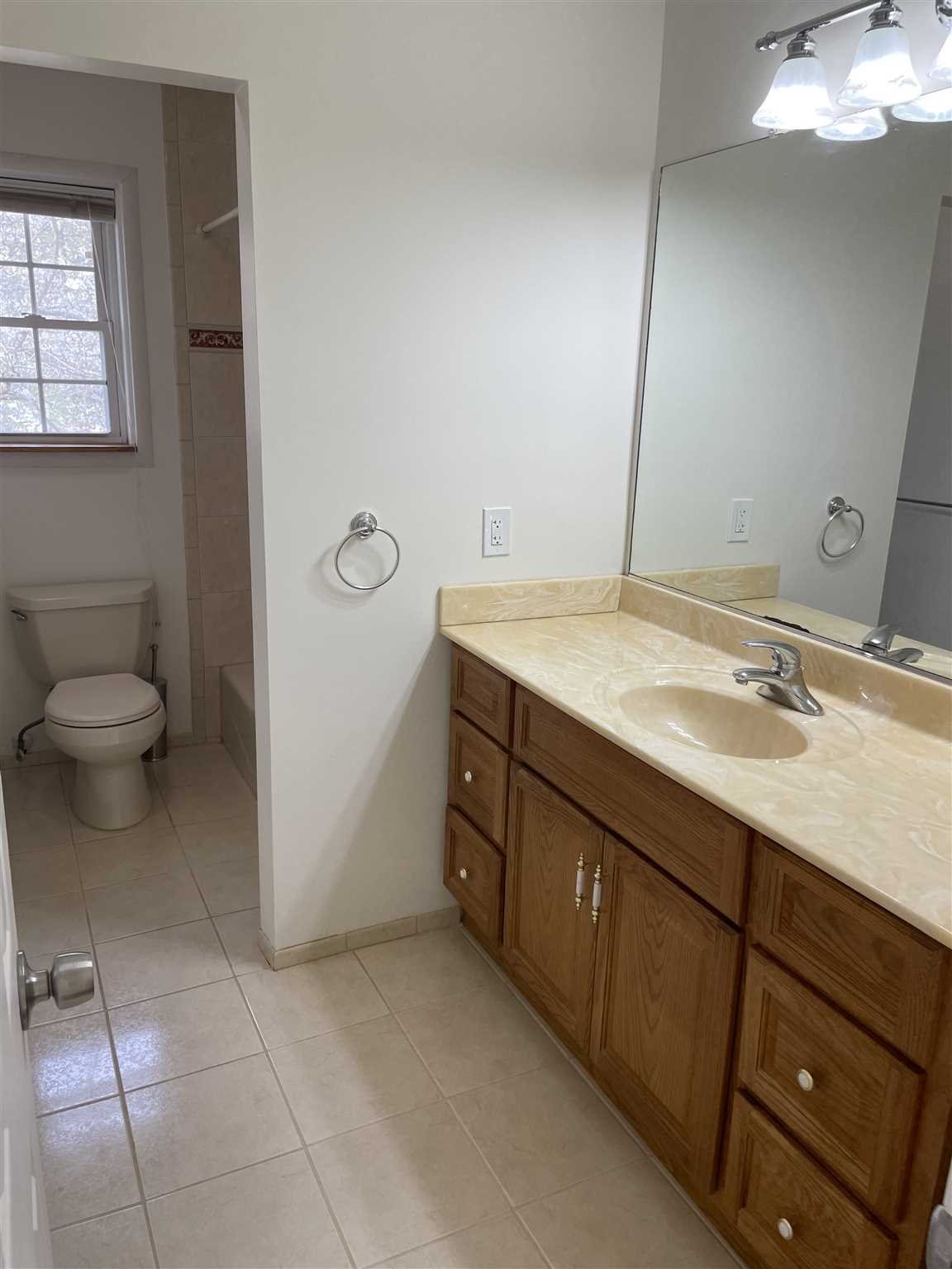 36 Sutton Park Road Poughkeepsie, NY 12603 - Photo 9 of 17 a bathroom with a granite countertop sink a toilet and a mirror
