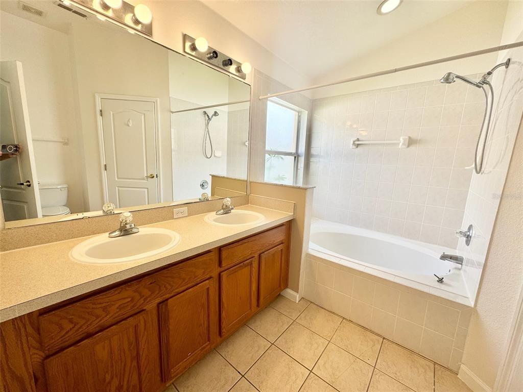 3103 Rawcliffe Road Clermont, FL 34714 - Photo 11 of 17 a bathroom with a tub sink shower and a mirror