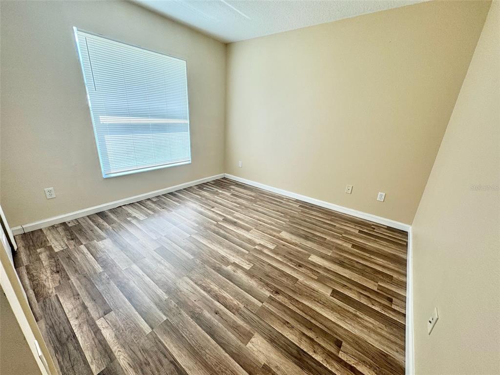 3103 Rawcliffe Road Clermont, FL 34714 - Photo 7 of 17 a view of an empty room with wooden floor and a window