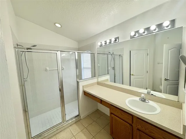 a bathroom with a double vanity sink mirror and shower