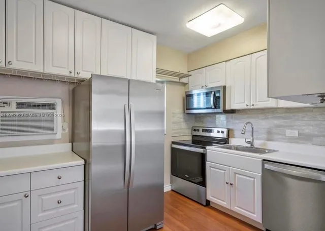 a kitchen with stainless steel appliances granite countertop a refrigerator sink and cabinets