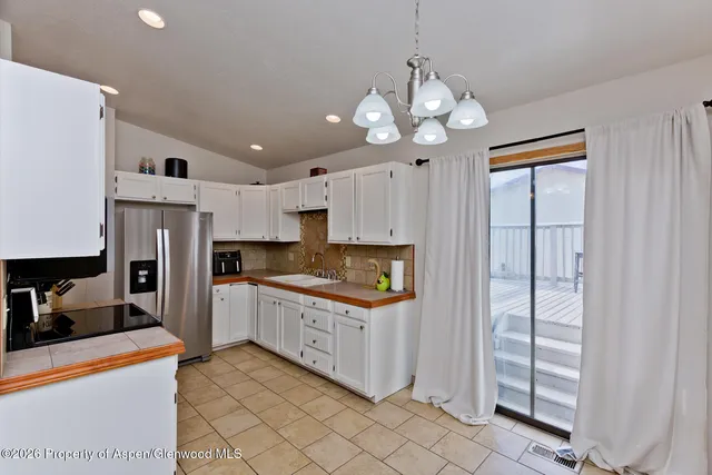 a kitchen with stainless steel appliances granite countertop a refrigerator and a stove top oven