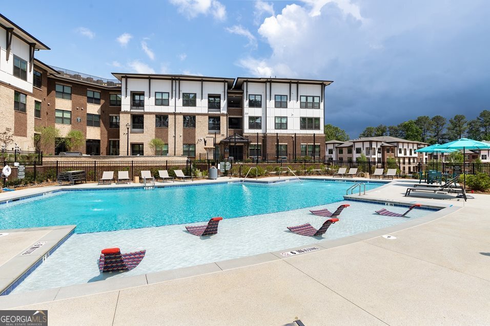 1399 Herrington Road, Unit 1202 Lawrenceville, GA 30044 - Photo 29 of 32 a view of building with outdoor space and swimming pool