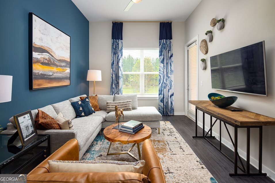 1399 Herrington Road, Unit 1202 Lawrenceville, GA 30044 - Photo 9 of 32 a living room with furniture a flat screen tv and a floor to ceiling window