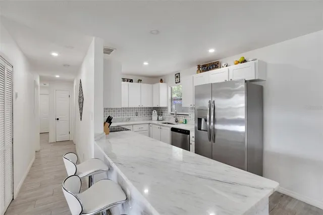 a kitchen with refrigerator and chairs