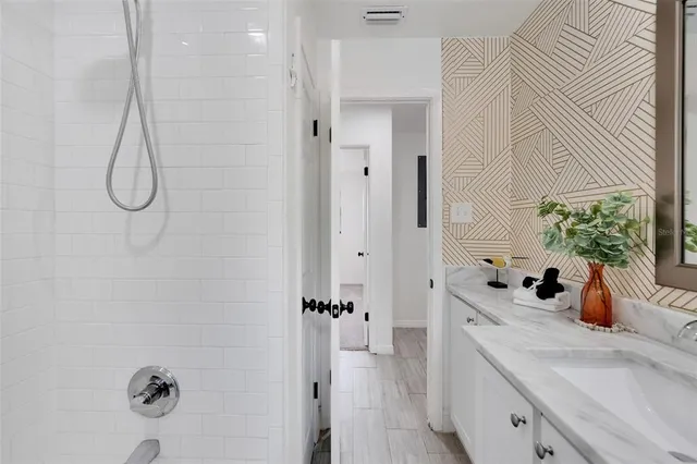 a bedroom with a bed and a lamp on the dresser