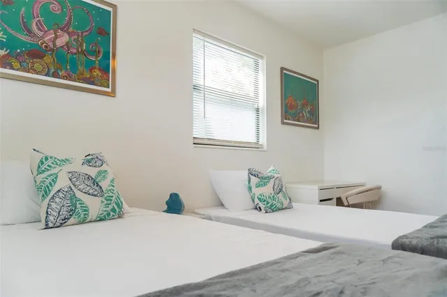 a bedroom with a bed and a lamp on the dresser