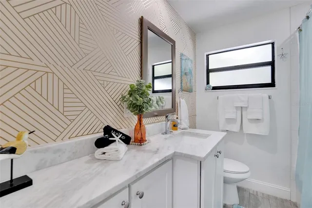 a bedroom with a large bed and a flat tv screen on dresser