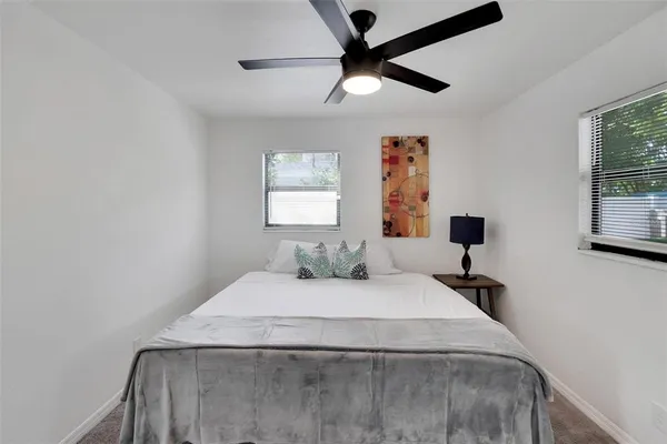 a view of backyard of house with seating space and trees in the background