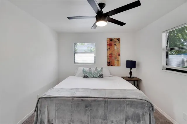 a view of backyard of house with seating space and trees in the background