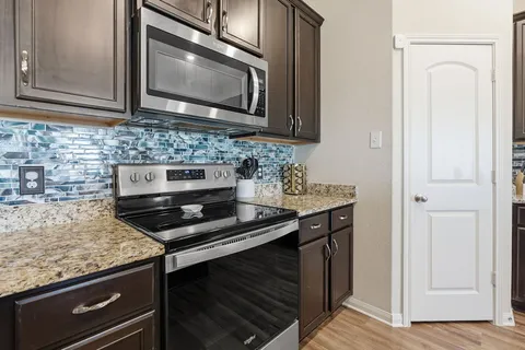a kitchen with stainless steel appliances granite countertop a stove and a microwave