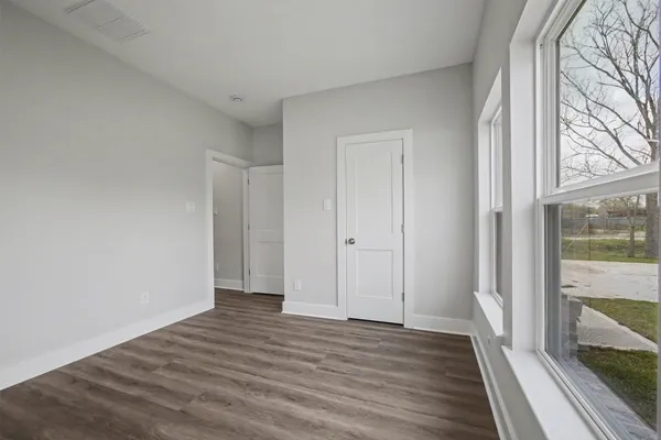 a view of a room with wooden floor and a window