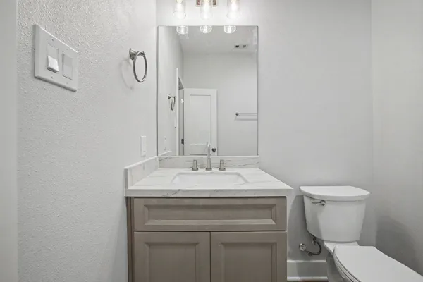 a bathroom with a sink toilet and a mirror