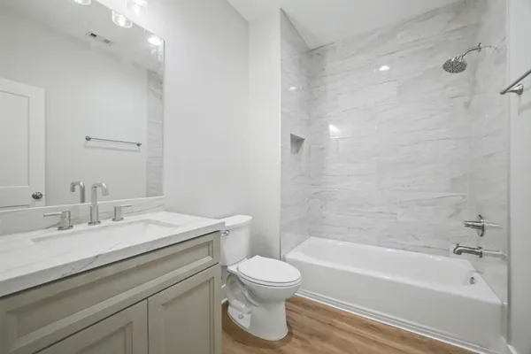 a bathroom with a granite countertop sink a toilet and bathtub