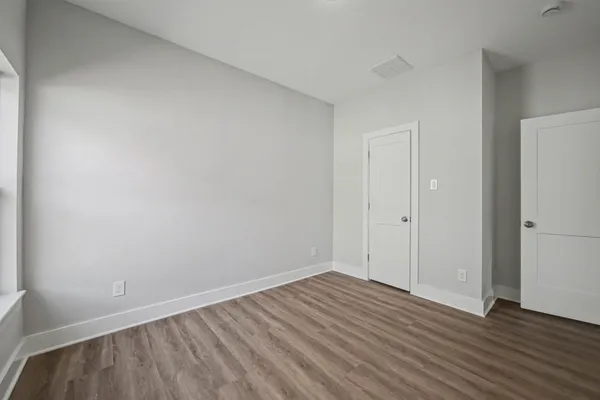 a view of an empty room with wooden floor