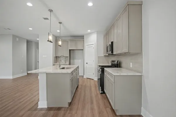 a large kitchen with a sink and cabinets