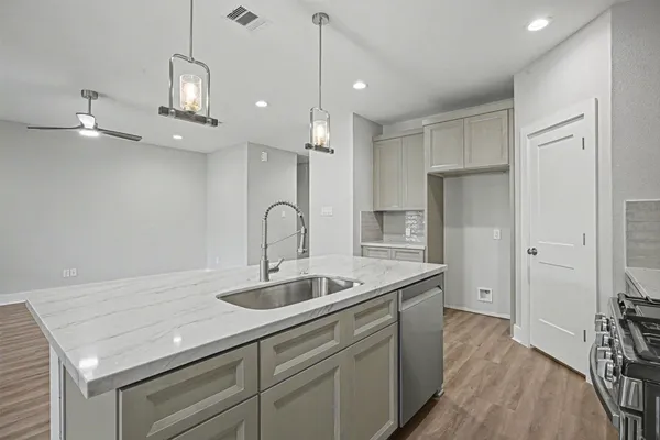 a kitchen with stainless steel appliances granite countertop a sink a refrigerator and a stove