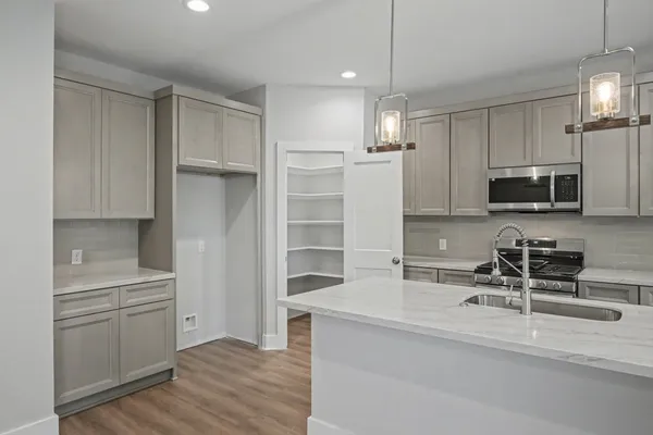a kitchen with stainless steel appliances a refrigerator sink and microwave