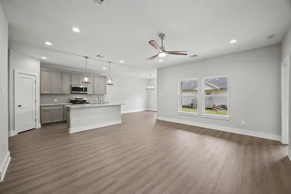 a view of kitchen with cabinets microwave and stove