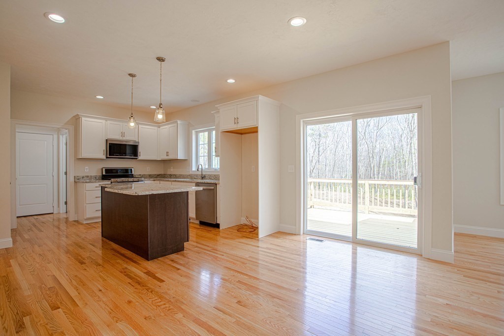 68 Little Turnpike Road Shirley, MA 01464 - Photo 13 of 40 a kitchen with stainless steel appliances kitchen island granite countertop a stove top oven a sink and a refrigerator