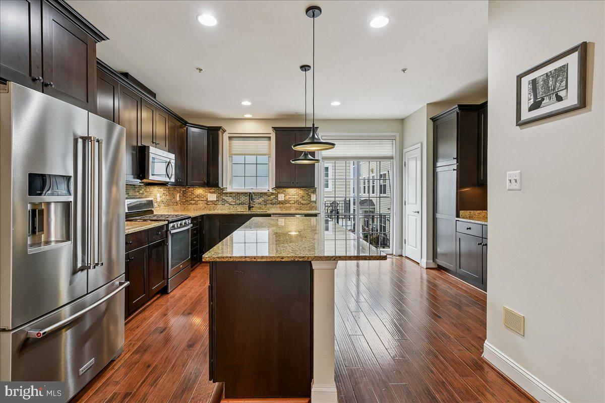 105 Meridian Lane Towson, MD 21286 - Photo 10 of 56 a kitchen with stainless steel appliances granite countertop a refrigerator a stove oven and a refrigerator with wooden floor