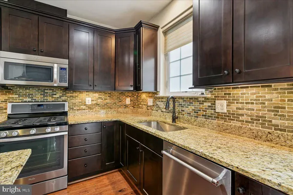 a kitchen with stainless steel appliances kitchen island a refrigerator sink and cabinets