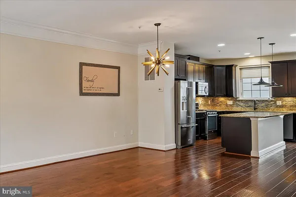 a kitchen with stainless steel appliances granite countertop a refrigerator a sink and a stove