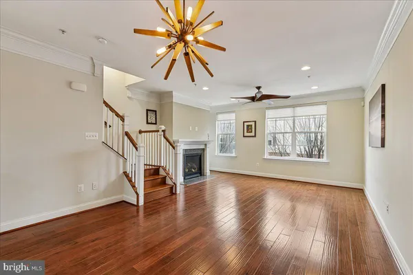 a view of a kitchen with wooden floor a ceiling fan and windows