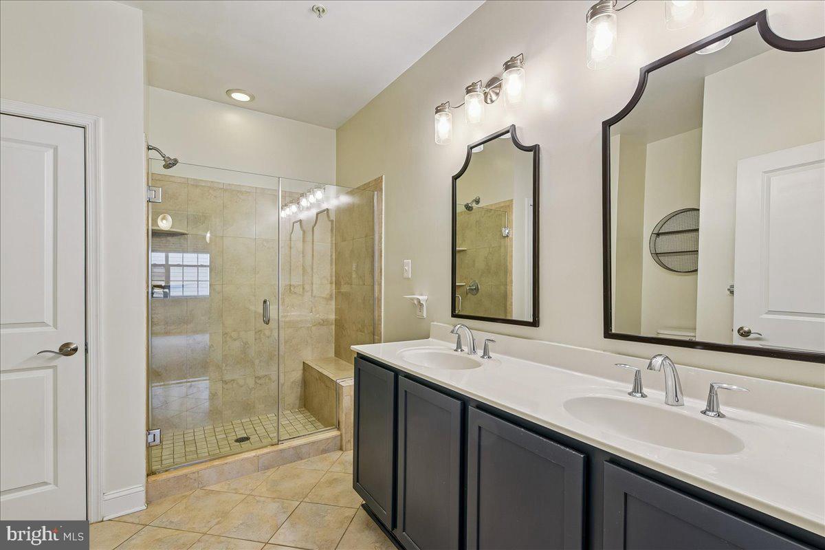 105 Meridian Lane Towson, MD 21286 - Photo 30 of 56 a bathroom with a double vanity sink mirror and shower
