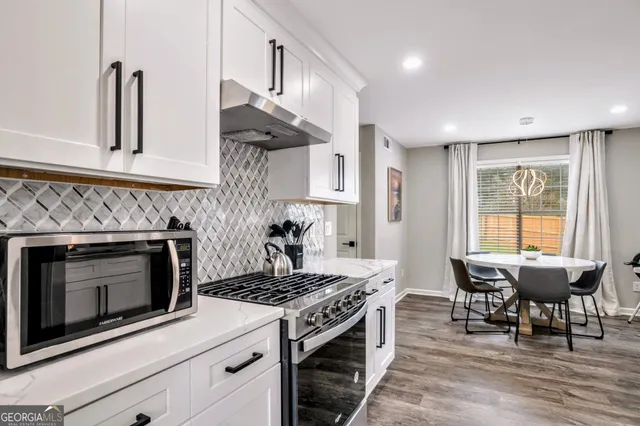 a kitchen with a stove and chairs