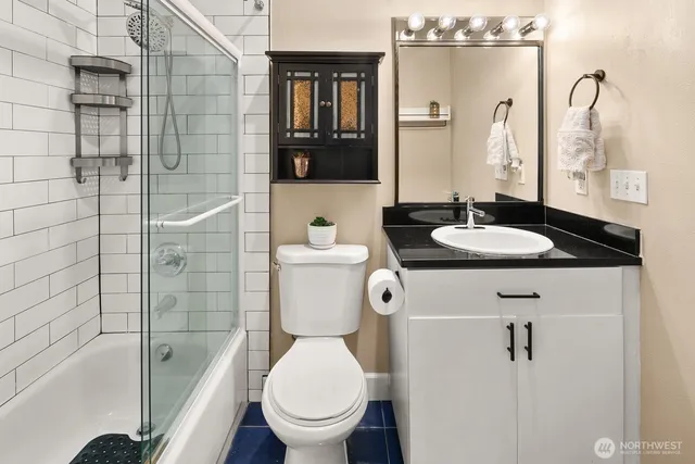 a bathroom with a granite countertop sink toilet and shower