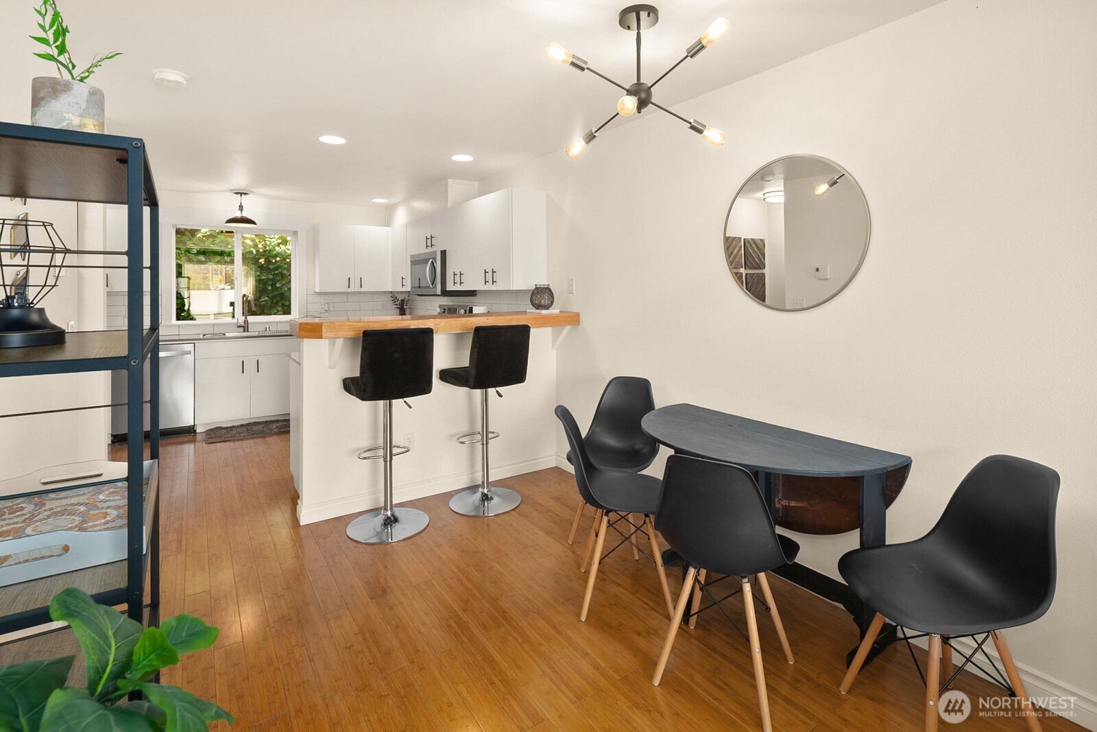 3224 21st Avenue West, Unit B Seattle, WA 98199 - Photo 5 of 17 a kitchen with a dining table chairs and white cabinets