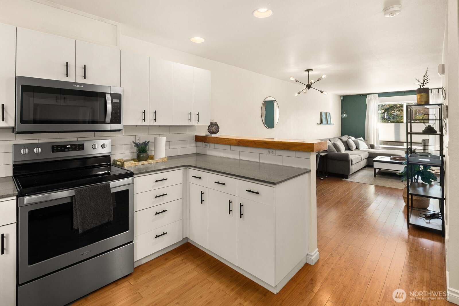 3224 21st Avenue West, Unit B Seattle, WA 98199 - Photo 7 of 17 a kitchen with stainless steel appliances a stove sink microwave and cabinets