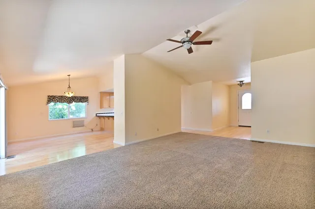 a view of a kitchen with wooden floor and a window