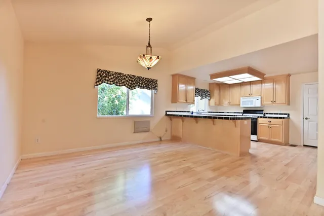a view of a kitchen with a sink and wooden floor