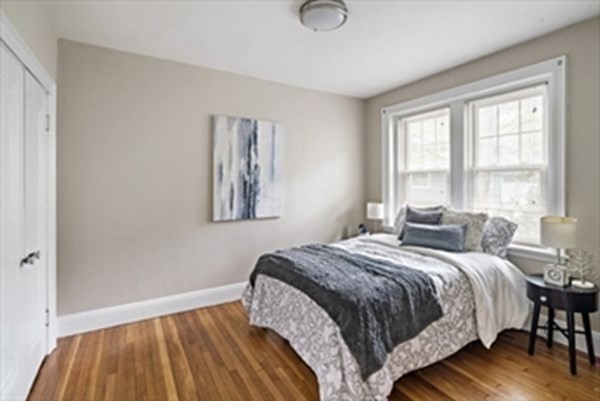52 Strathmore Road, Unit 25 Boston, MA 02135 - Photo 7 of 12 a bedroom with a bed and wooden floor