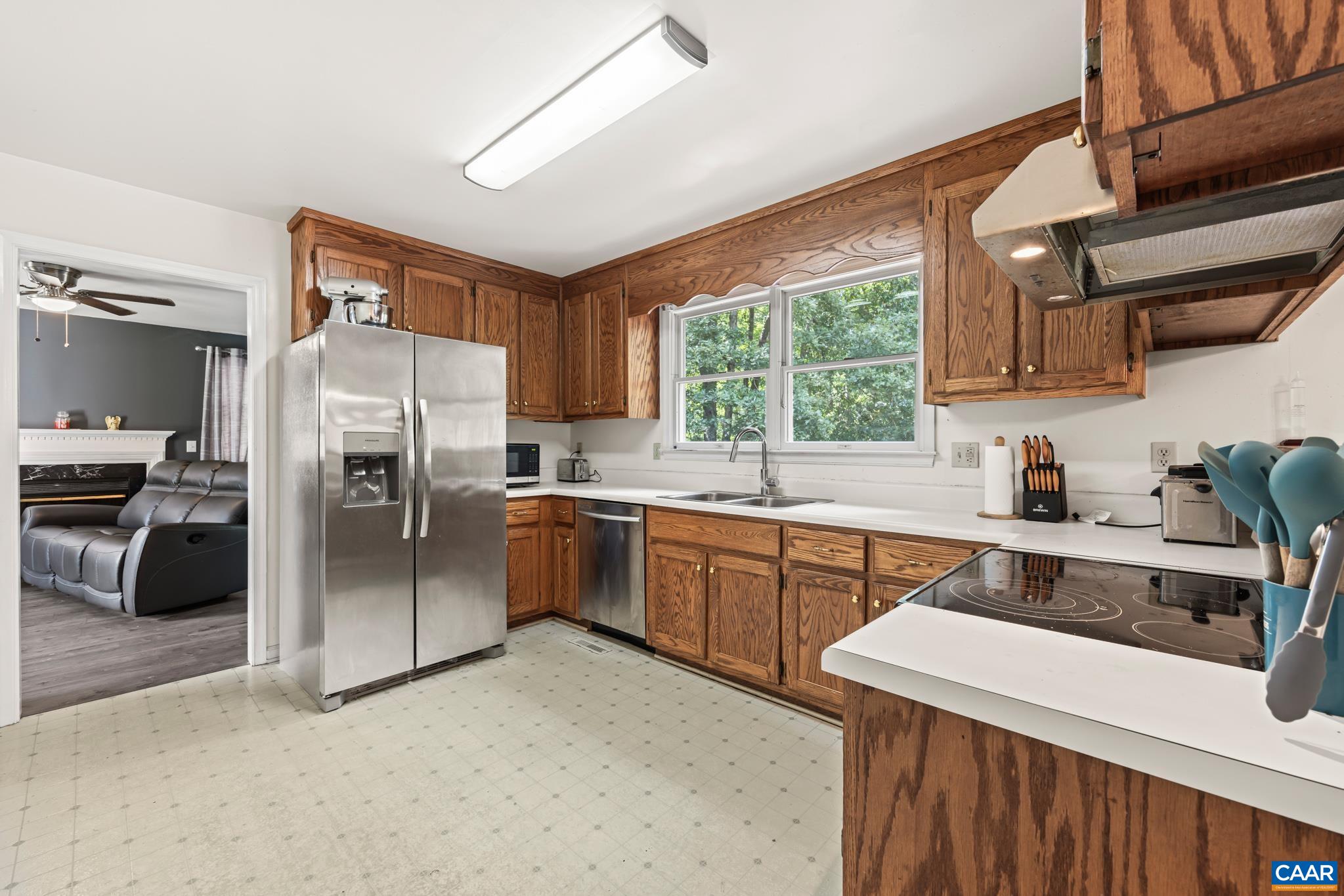 858 James River Road Scottsville, VA 24590 - Photo 13 of 33 a kitchen with stainless steel appliances a refrigerator sink and wooden cabinets