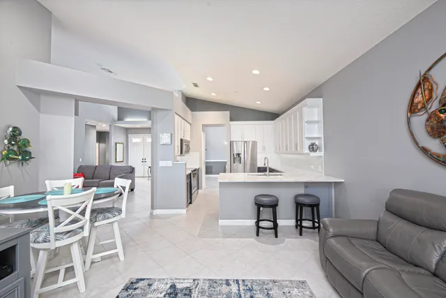a living room with furniture a table and kitchen view