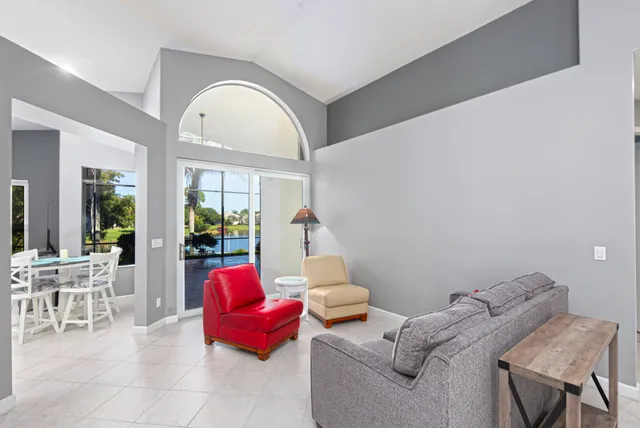 a living room with furniture chess table and a potted plant