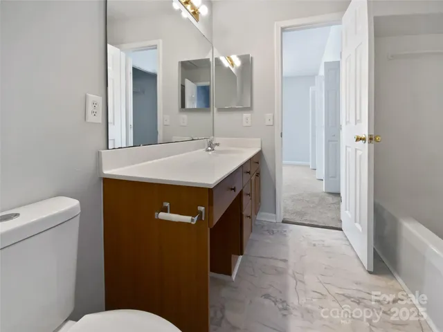 a bathroom with a sink a toilet a mirror and vanity