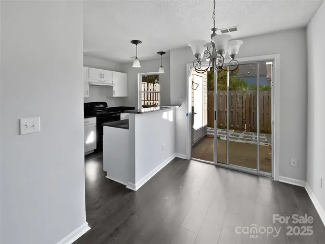 a view of a kitchen with a sink and dishwasher with wooden floor