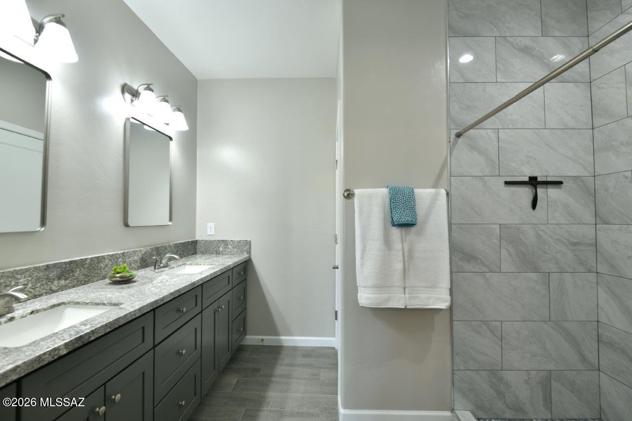 1091 North Vail View Road Vail, AZ 85641 - Photo 20 of 43 a bathroom with a granite countertop shower sink and mirror