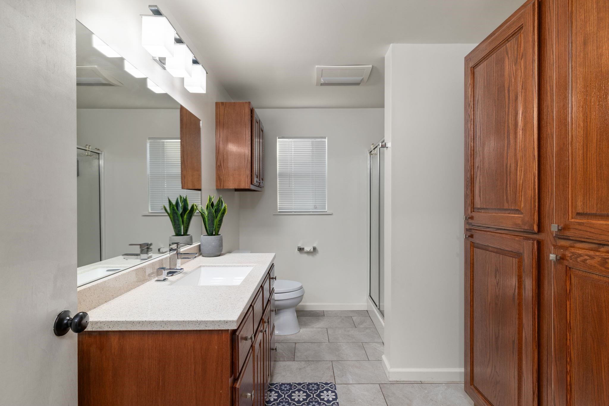 66 County Road 511 Corinth, MS 38834 - Photo 25 of 40 Bathroom featuring a wood vanity with a light-toned countertop, an integrated sink, a large wall mirror, and a multi-bulb vanity light fixture