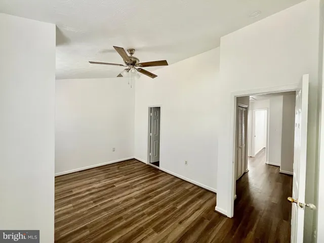 a view of a room with wooden floor and a ceiling fan