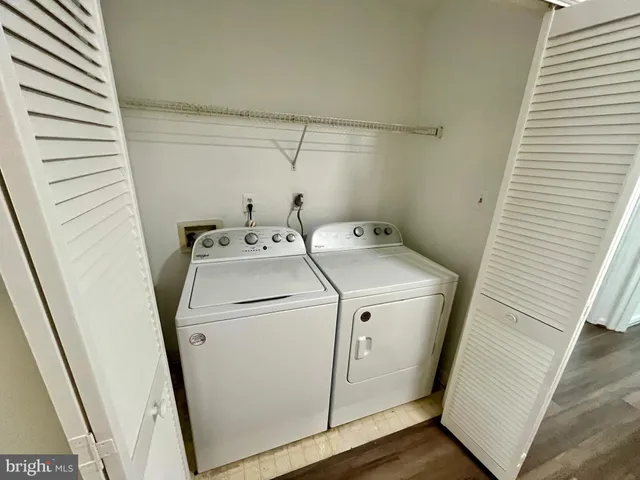 an empty room with wooden floor fireplace and windows