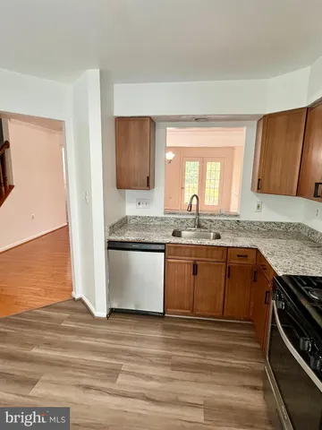 a kitchen with granite countertop wooden cabinets stainless steel appliances and a window
